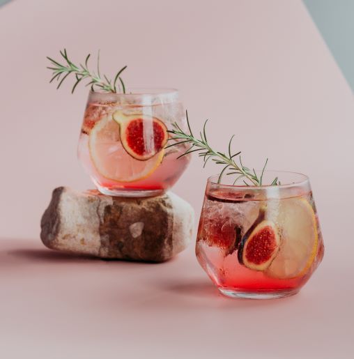Pink gn in two glasses with thyme on the top