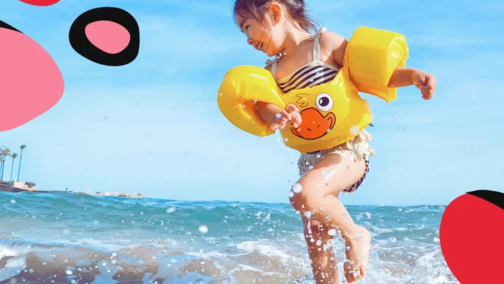 4yr old girl playing in the summer hoidays on abeach with duck arm bands