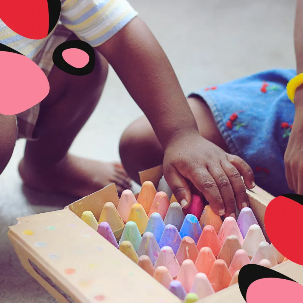 toddler playing with coloured crayons