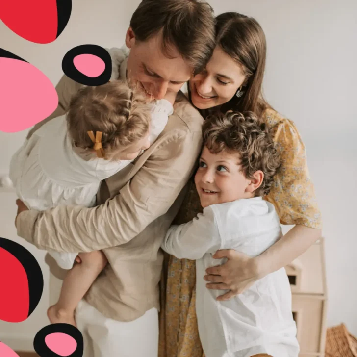 family of four hugging showing How To Cut Expenses On The Family Budget