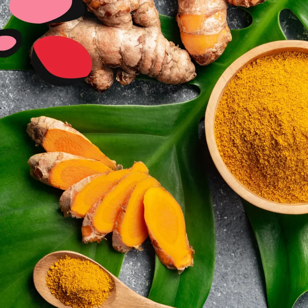 turmeric in a bowl and on the table on bright green leaves