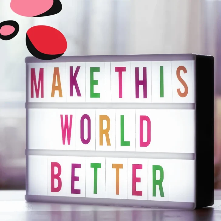 sign saying make this world better in different colour letters