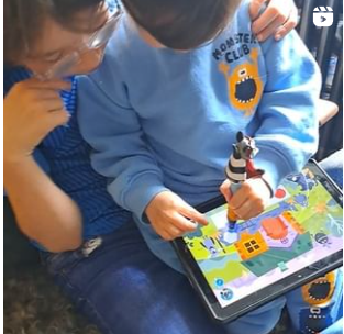 two children sitting with the edurino app open and pen