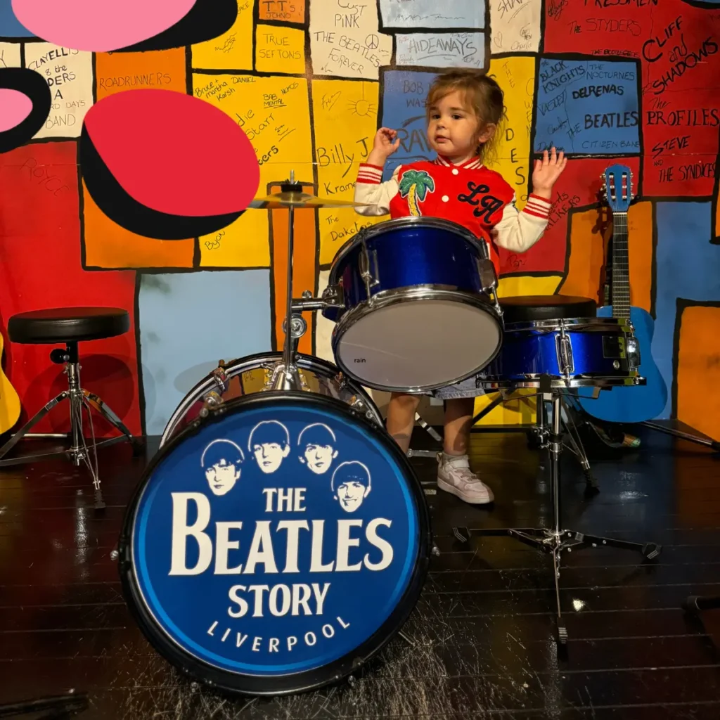 little girl playing the drums at the liverpool beatles museum