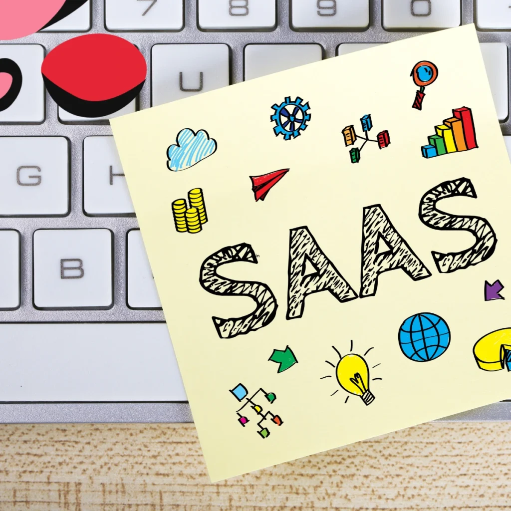 saas stack written on a post it note with doodles on it on a laptop.
