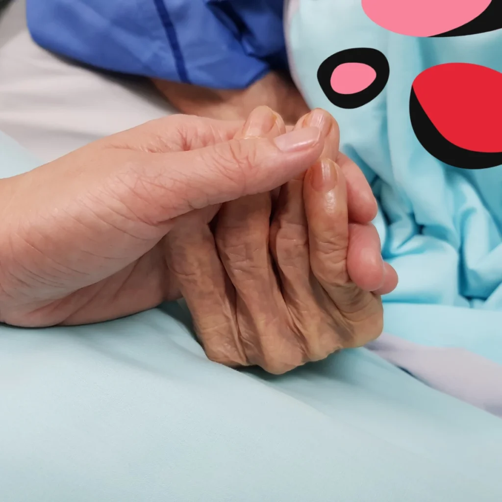 people holding hands as patient is end of life