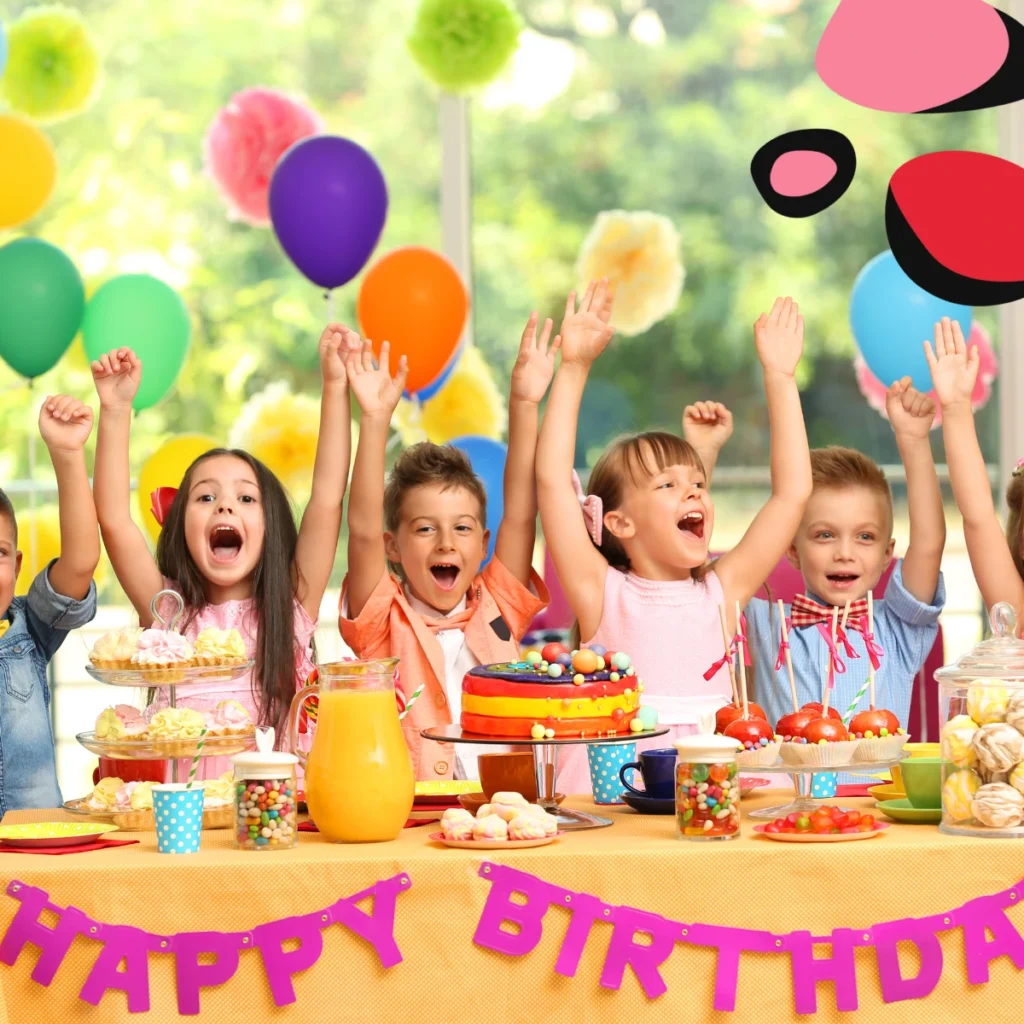 kids celebrating in front of a happy birthday table with cake and presents