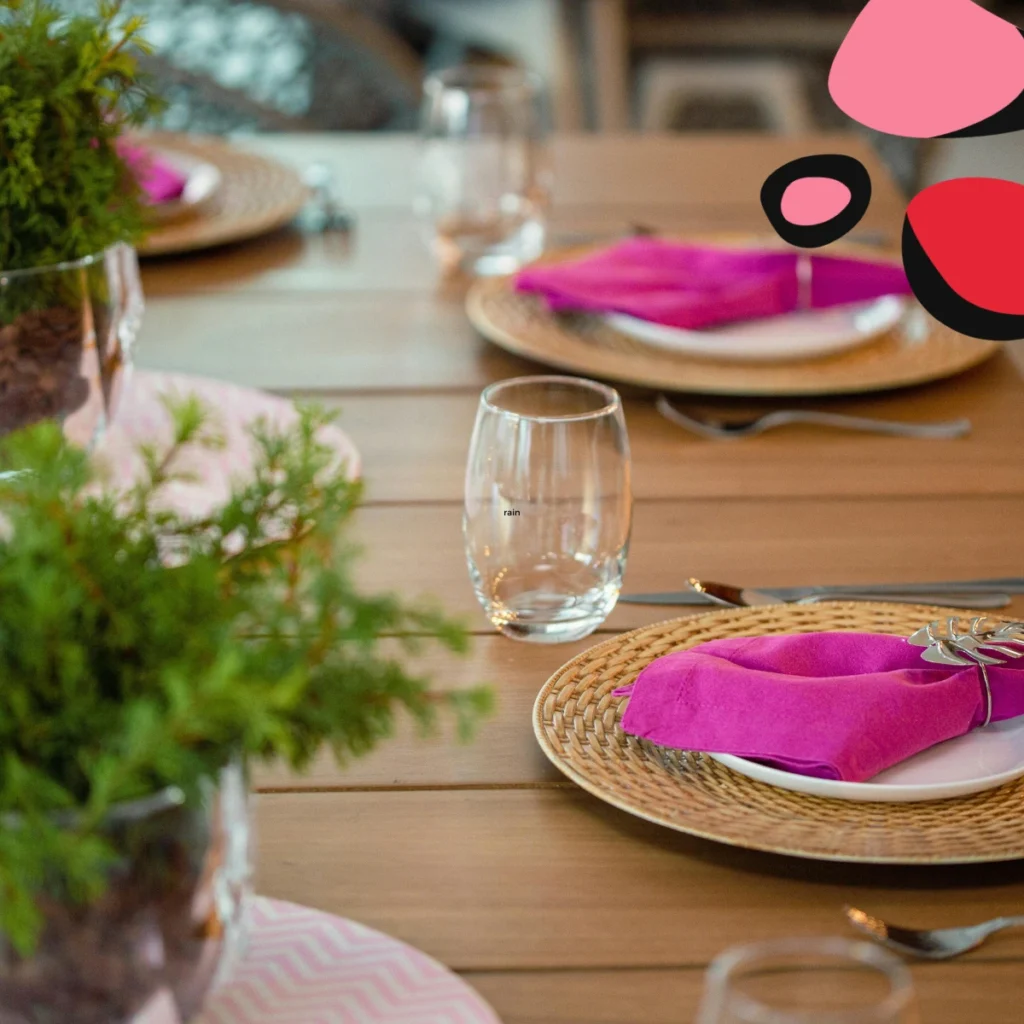 restaurant table set with pink napkins on a brown wodden table