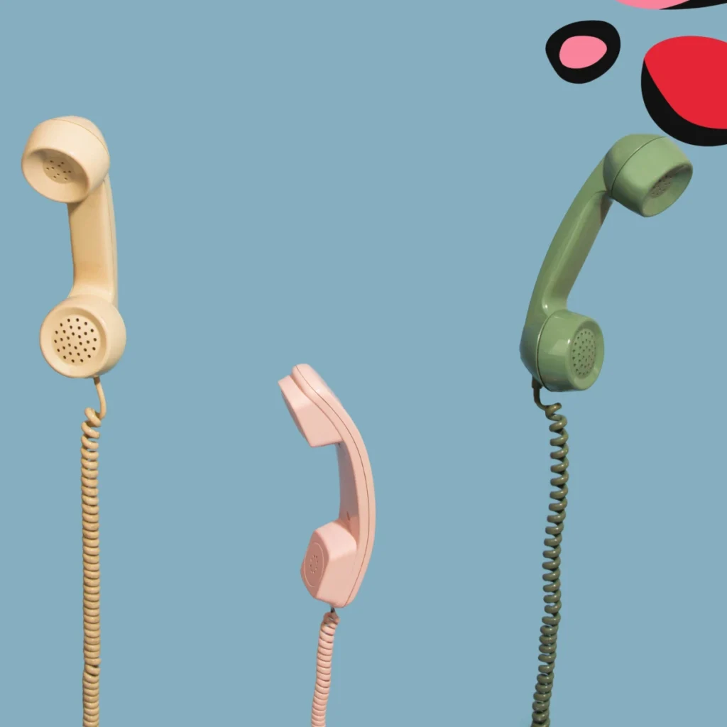 3 telephone headsets with wires on a blue background