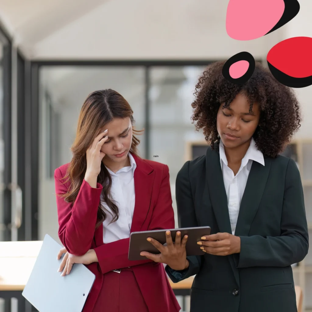 two women holding a laptop report business in crisis with hands on head